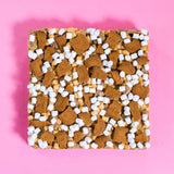 Biscoff Rocky Road by Crumbs & Doilies topped with Biscoff chunks, marshmallows, and white chocolate on pink background